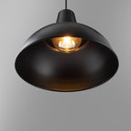 Foundry black pendant light lit, warm glow