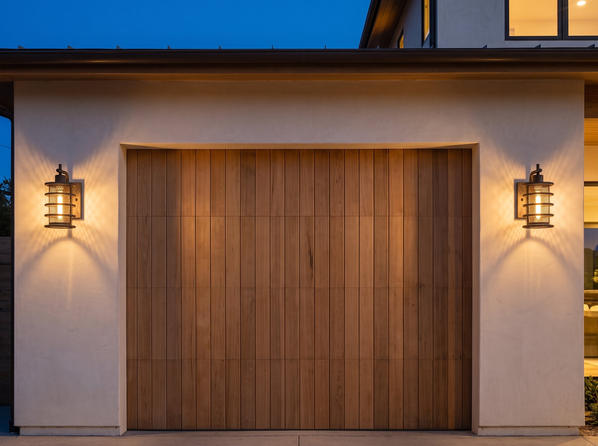 Two Wire Cage sconces flanking a garage door at dusk